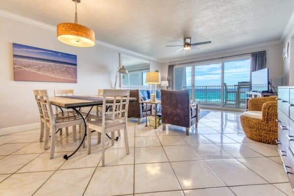 Beachfront dining interior at the Beach House Condos, with balcony displaying a panoramic ocean view.