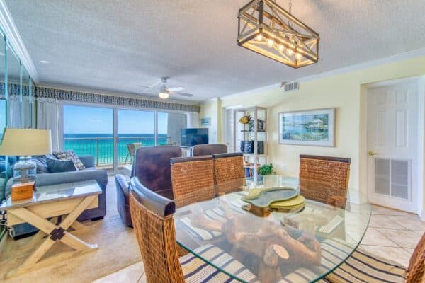 Beachfront condo living room with a glass table, brown sofas, and ocean view through large windows with A403 steel fittings.