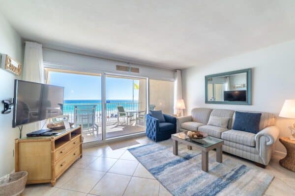 Bright living room at Beach House Condos with an ocean view from the balcony.
