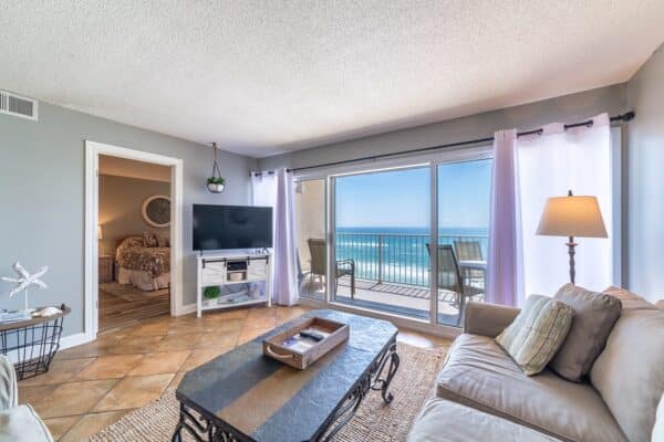 Beachfront living room with ocean view through sliding glass doors at D602 in The Beach House Condominiums.
