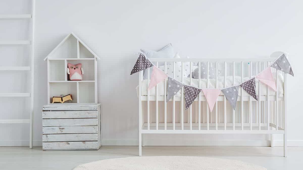 A minimalist baby's nursery at The Beach House Condominiums, featuring a white crib.