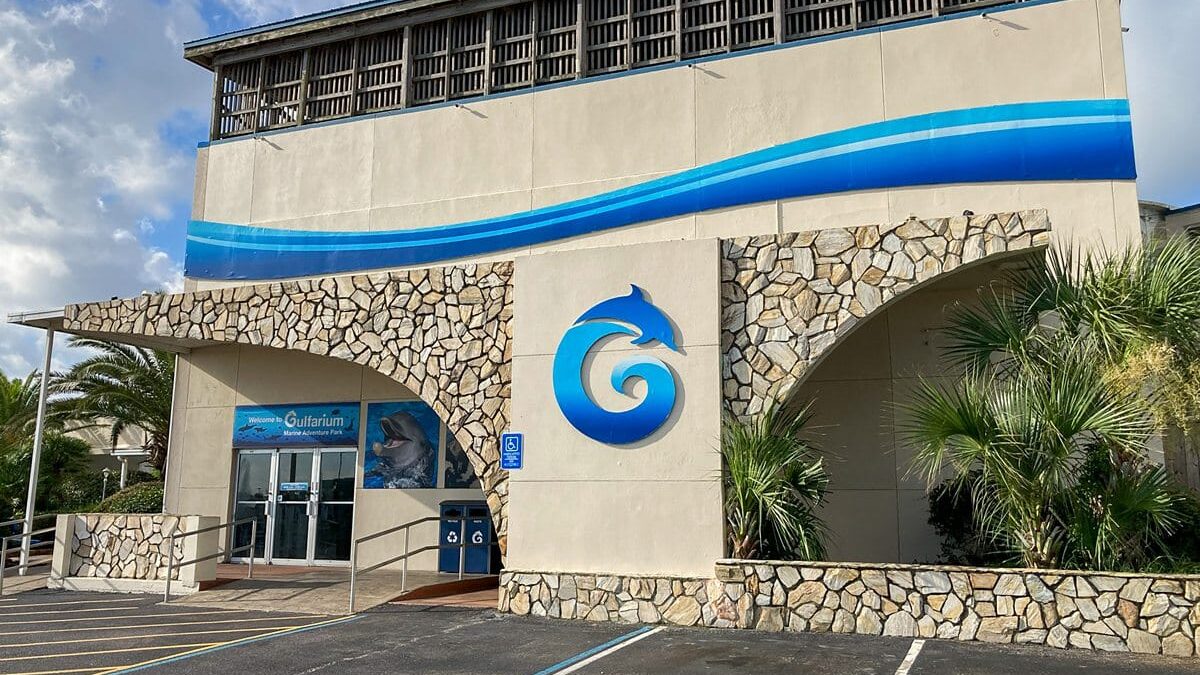 Entrance of an aquarium with a blue wave design at The Beach House Condominiums.