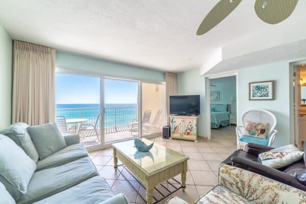 Oceanfront living room with balcony at The Beach House Condominiums, overlooking the sea.