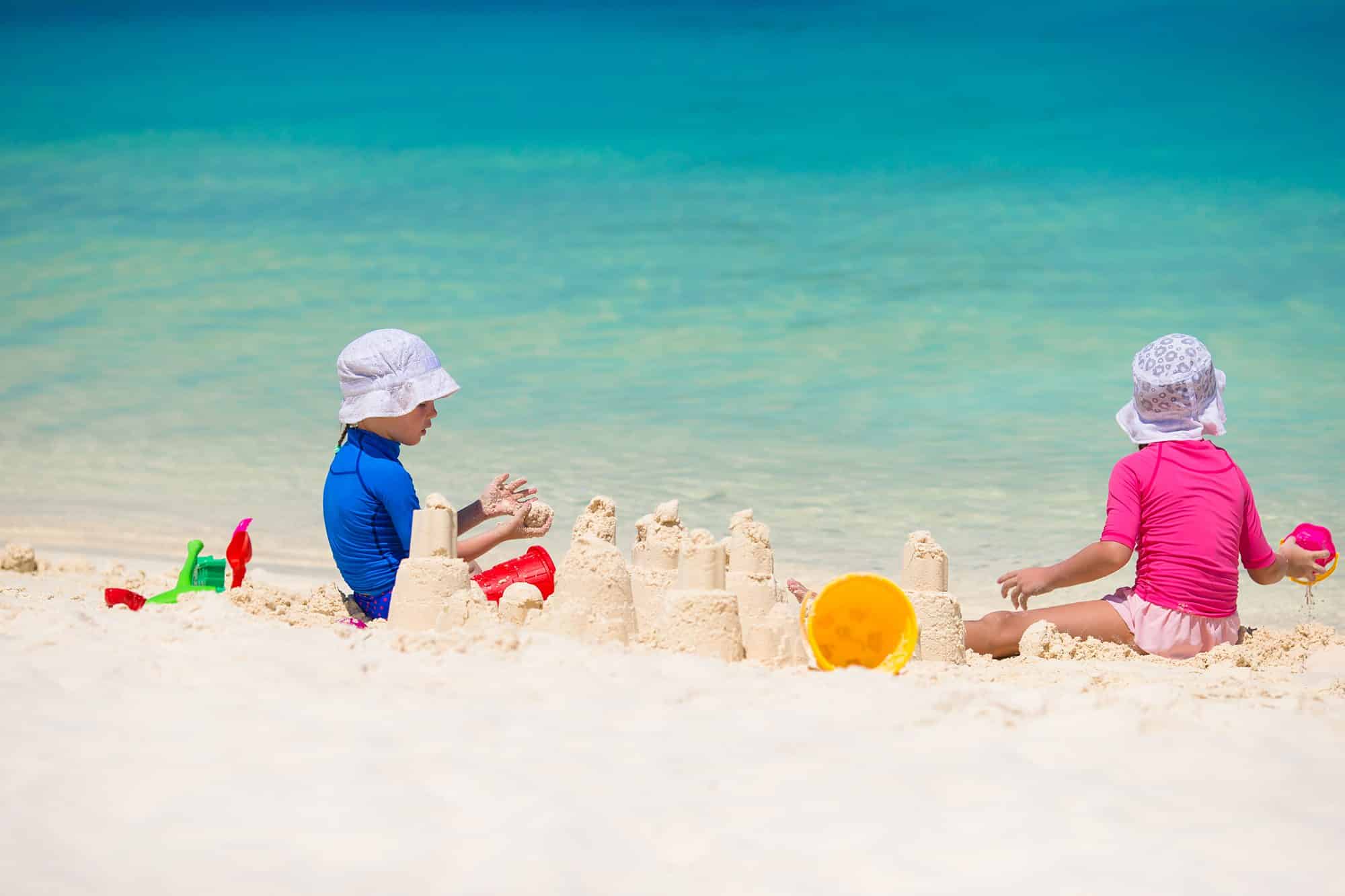 Kids participating in activities, building a sandcastle at The Beach House Condominiums.