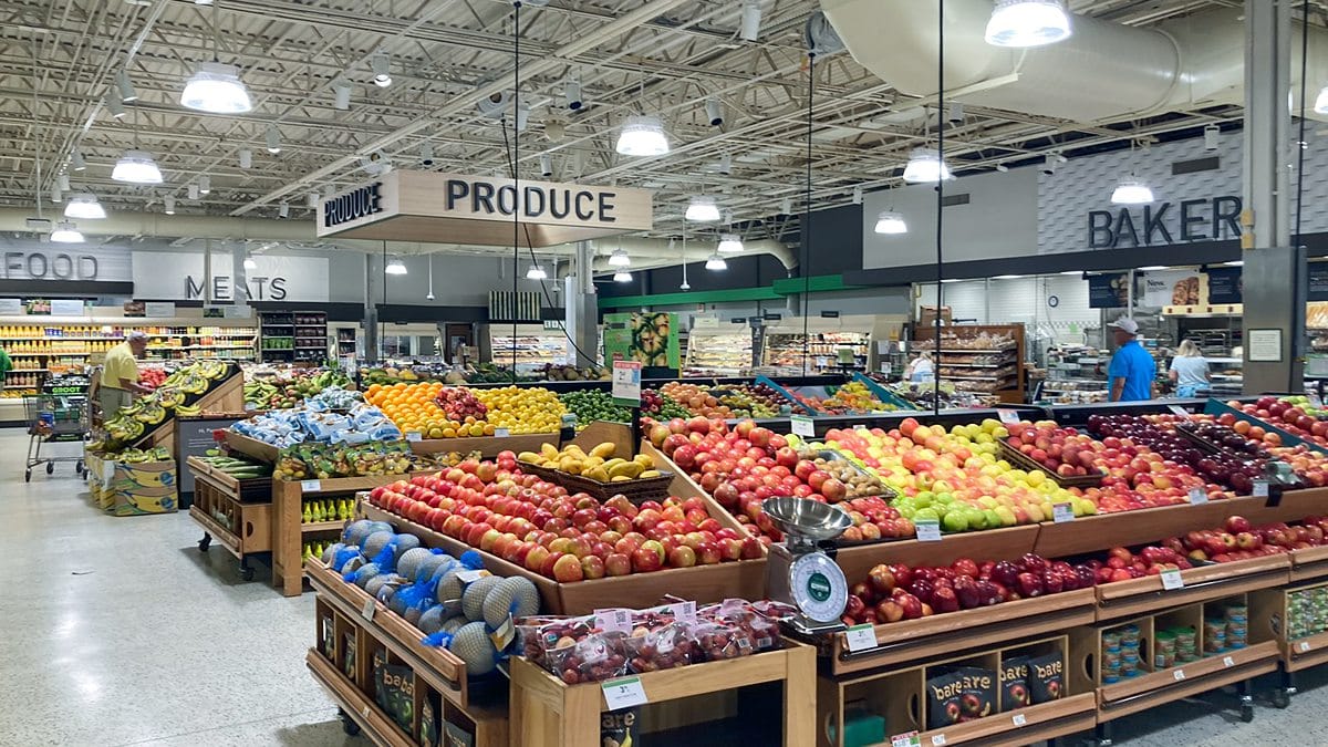 Produce aisle in a grocery store near the Beach House Condominiums, with a bakery section visible.