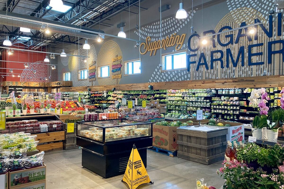 Inside a brightly lit store near the Beach House Condominiums selling organic produce, with a sign advocating for local farmers.