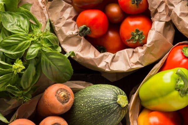 Variety of fresh vegetables from a local grocery in Beach House Condominiums on a wooden surface.