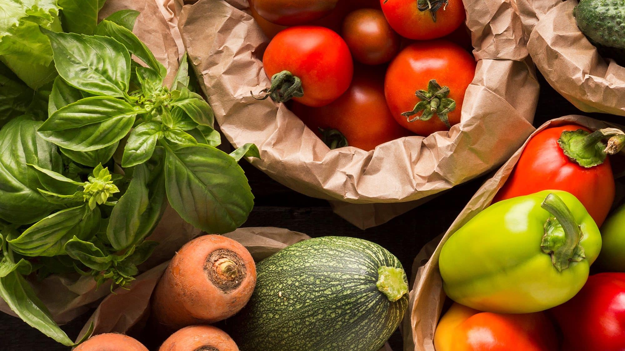 Variety of fresh vegetables from a local grocery in Beach House Condominiums on a wooden surface.