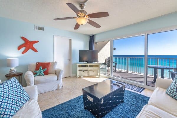 Coastal-themed living room in C602 model at The Beach House Condominiums with ocean view balcony.