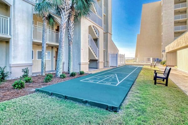 Outdoor shuffleboard court with bench at The Beach House Condominiums.